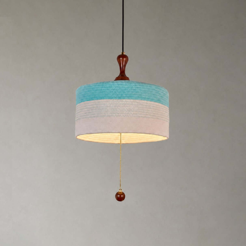 Close view of the blue and white woven drum shade, wooden finial and beaded pull chain on this Clérachic pendant.