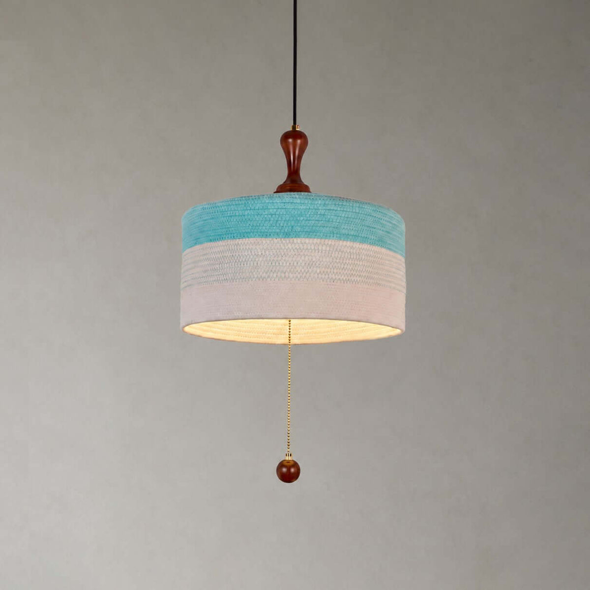 Close view of the blue and white woven drum shade, wooden finial and beaded pull chain on this Clérachic pendant.