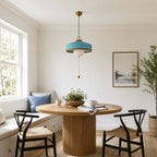 This Clérachic pendant in blue hangs in a breakfast corner with a window seat, a round table and two black chairs.