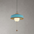 Blue woven shade with a copper-toned inner rim, white glass globe and wooden pull bead on this Clérachic pendant, on grey.