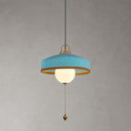 Blue woven shade with a copper-toned inner rim, white glass globe and wooden pull bead on this Clérachic pendant, on grey.