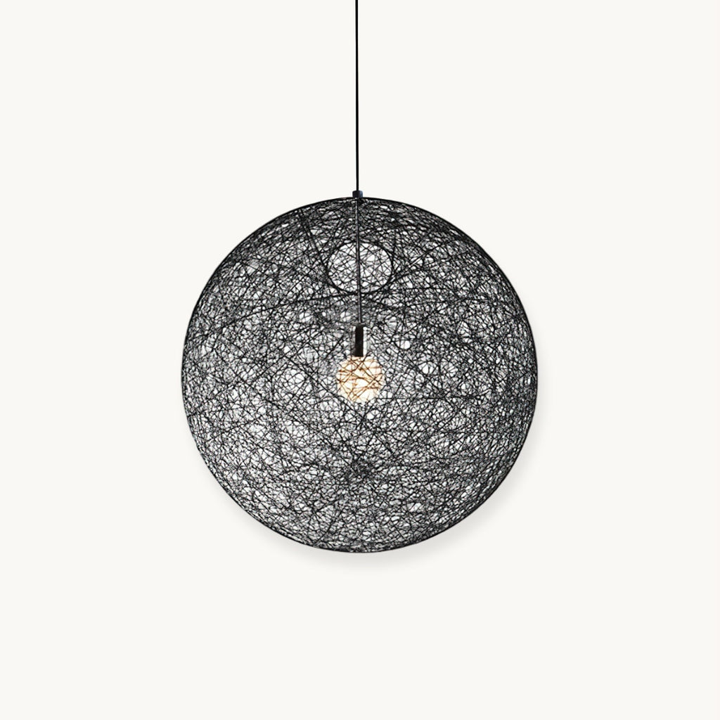 A black woven spherical Clérachic pendant light with a bulb glowing inside, hung on a black cord against a white backdrop.
