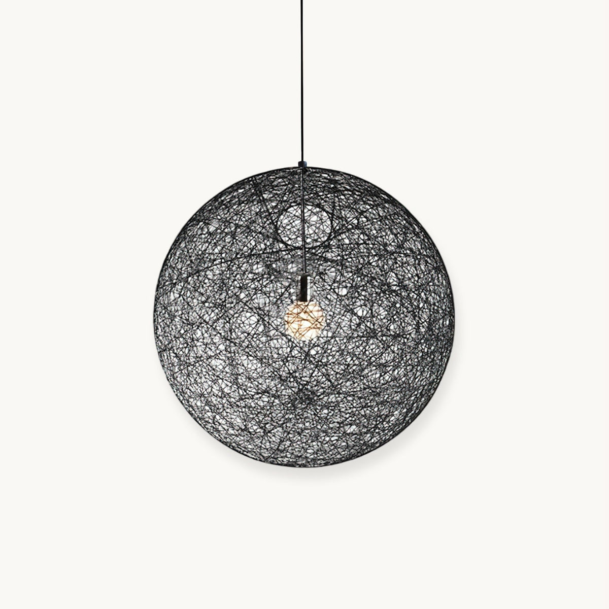 A black woven spherical Clérachic pendant light with a bulb glowing inside, hung on a black cord against a white backdrop.