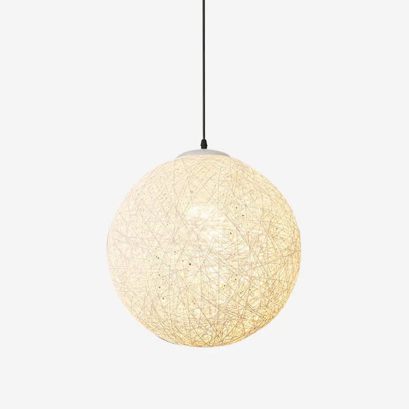 An off-white woven spherical Clérachic pendant light, lit warm from inside, on a black cord against a pale backdrop.