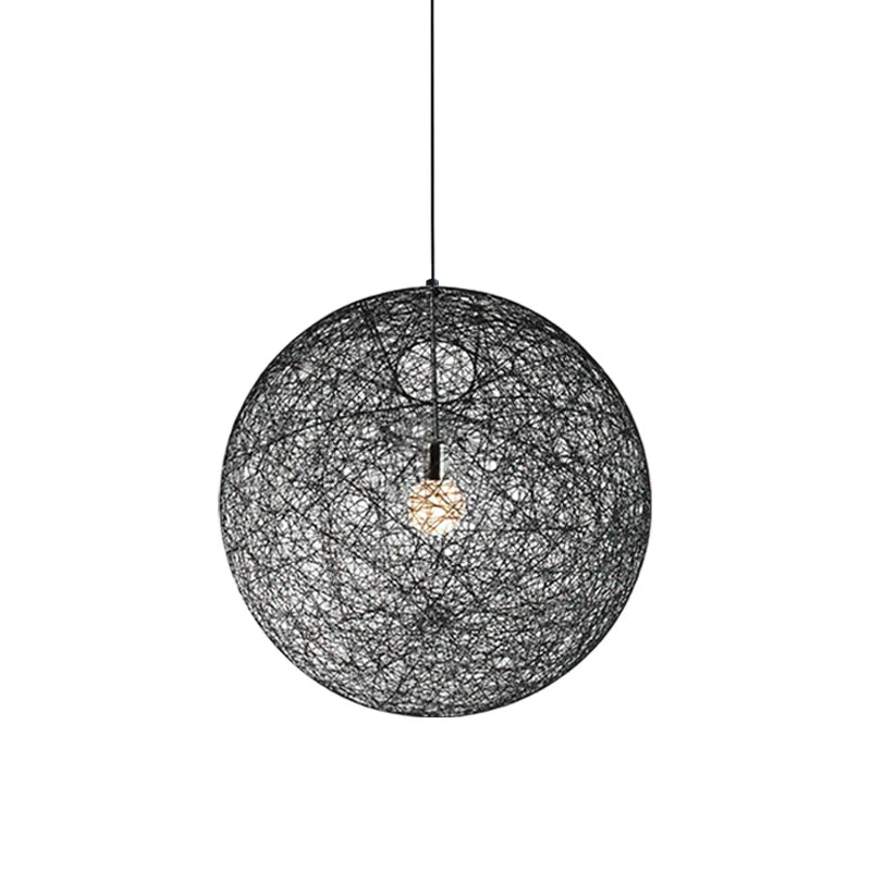 A black woven spherical Clérachic pendant light, unlit, with a bulb visible inside, on a black cord against white.