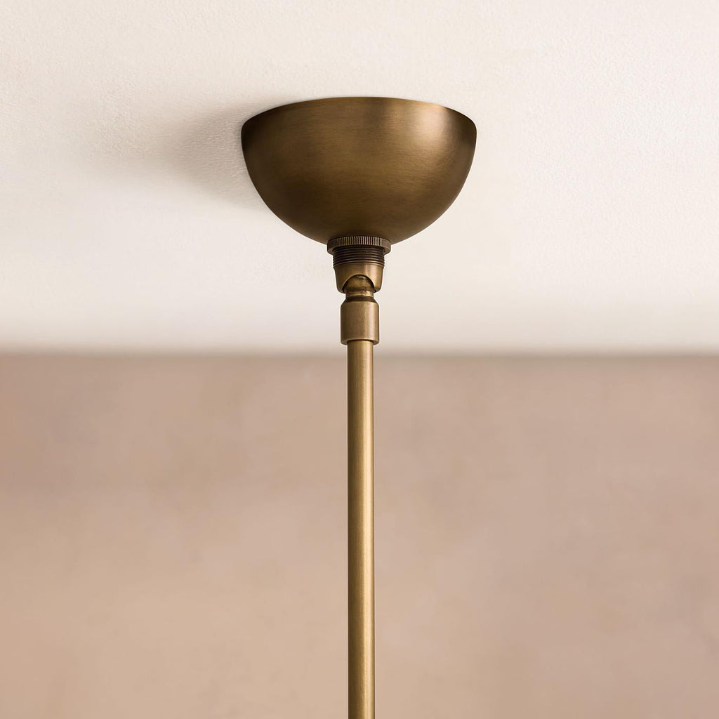 Clérachic Xenon ceiling canopy detail — a domed brushed brass mount with the slim brass drop rod running below it.