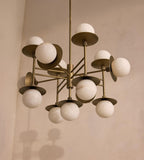 The Clérachic Xenon chandelier viewed from below, its brass spokes fanning out beneath a limewashed ceiling.