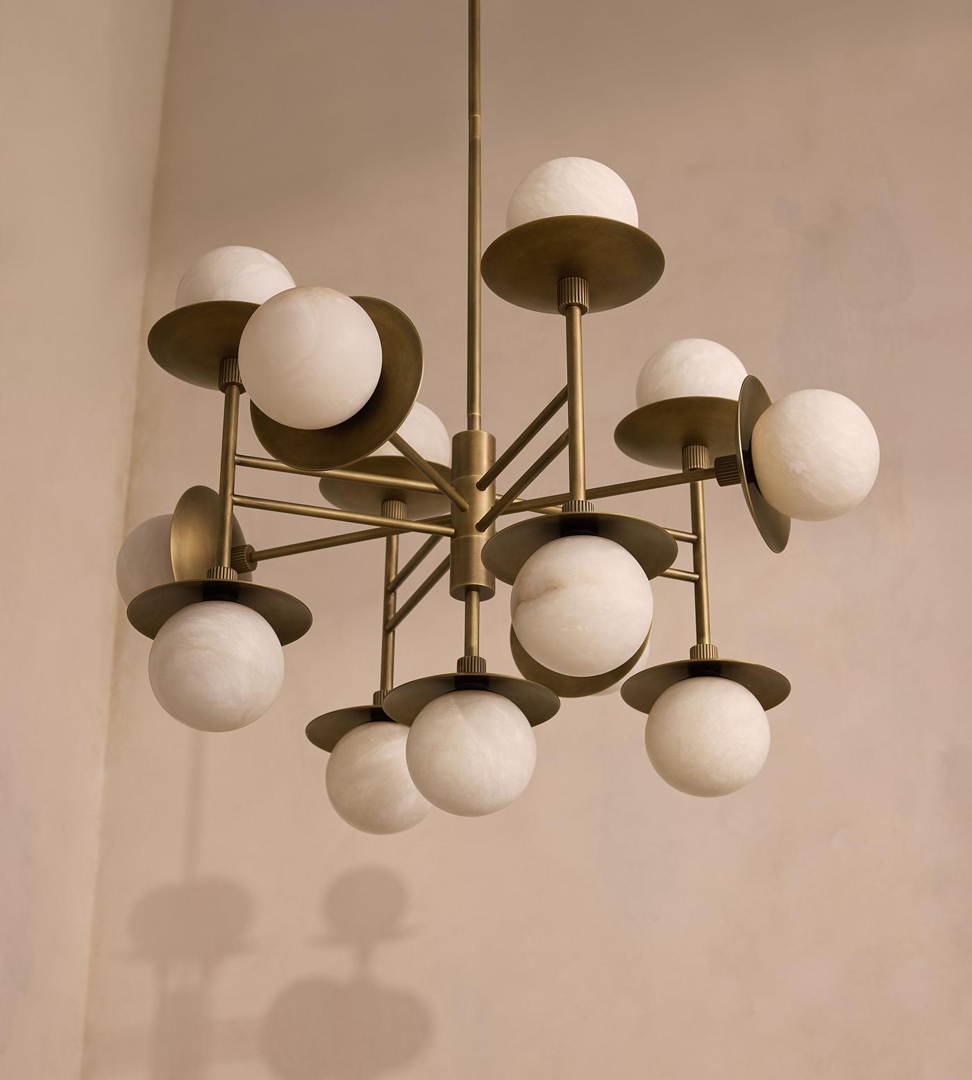 The Clérachic Xenon chandelier viewed from below, its brass spokes fanning out beneath a limewashed ceiling.