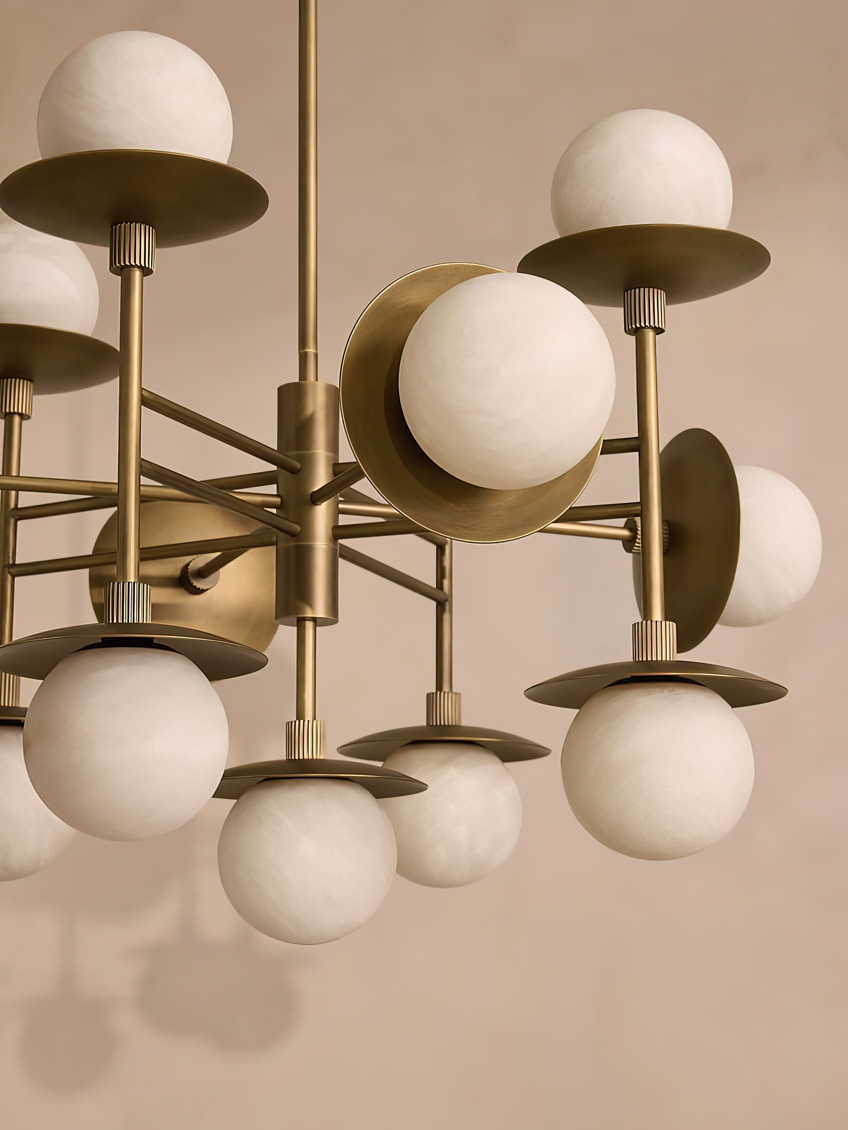 Clérachic Xenon chandelier close up, showing the brass discs, the central hub and the natural grain of the alabaster.