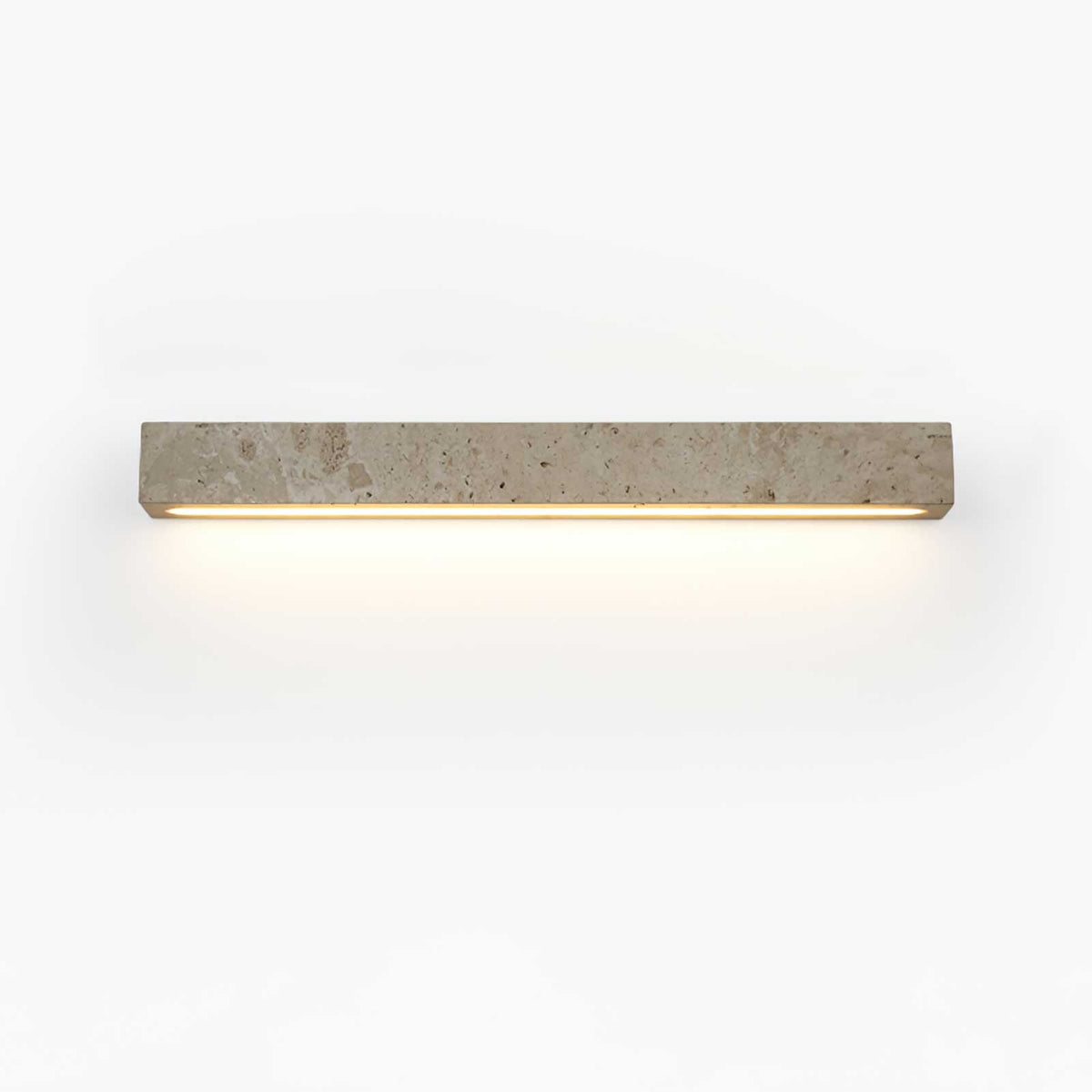 A pale travertine Clérachic wall light with a warm LED strip along its underside, on a white backdrop.