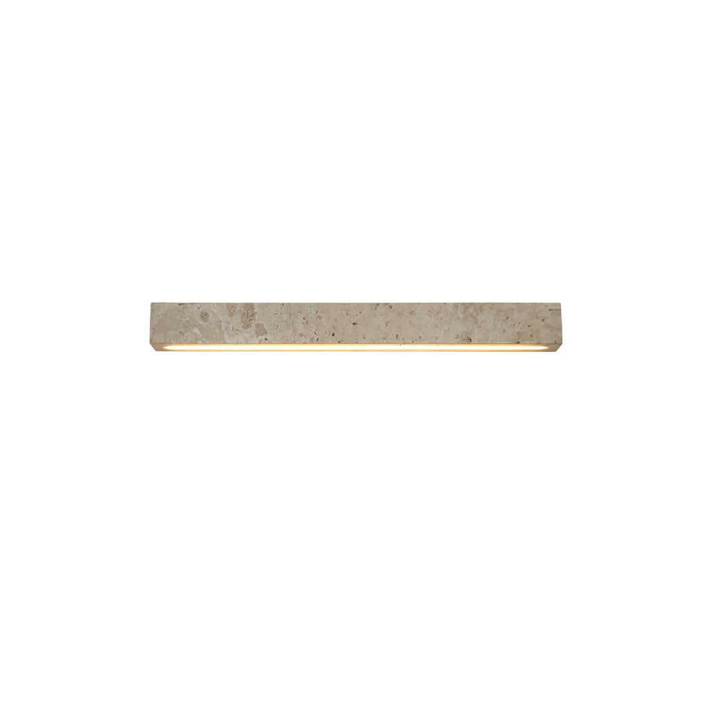 A pale travertine Clérachic wall light with a warm underside glow, shown small on a white backdrop.