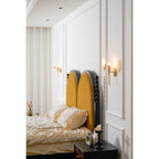 A pair of Clérachic wall lights flanking the bed, seen down the length of a curtained bedroom.