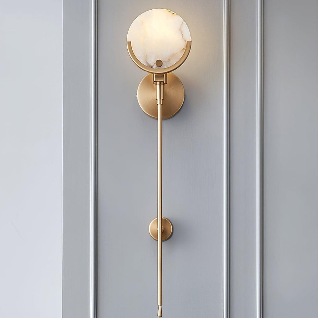 Clérachic sconce against grey panelling, the veined alabaster shade above a slim brass stem and low tie-back.