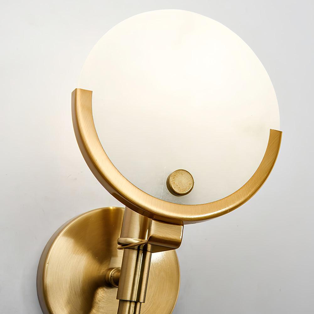 Close-up of the Clérachic shade seated in its brushed brass crescent, with the knurled fixing knob and backplate.