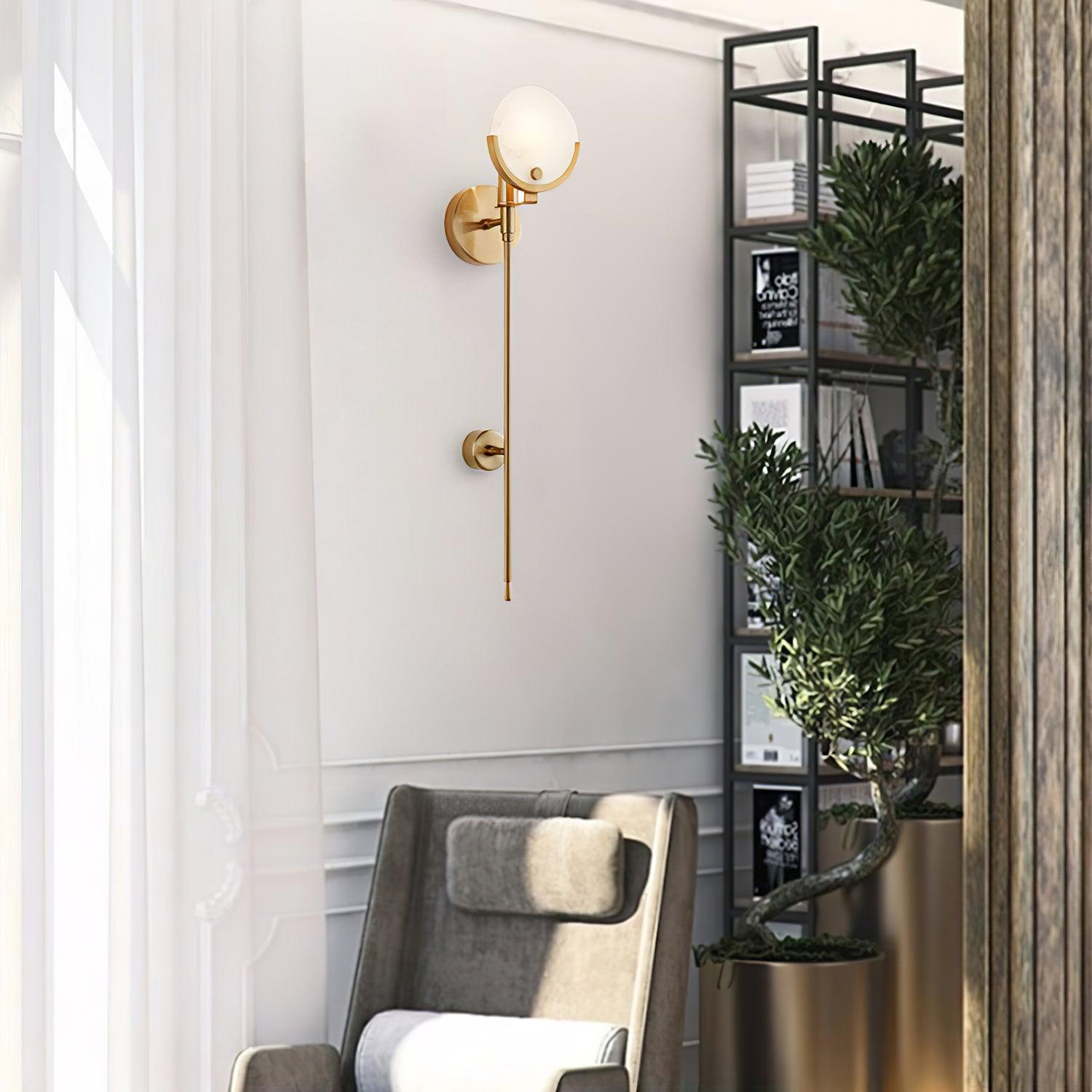 The Clérachic wall light beside a sheer-curtained window, with an armchair and black shelving behind.