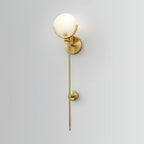 The Clérachic wall light on a pale wall, round backplate, globe shade and long stem with its mid-point clip.