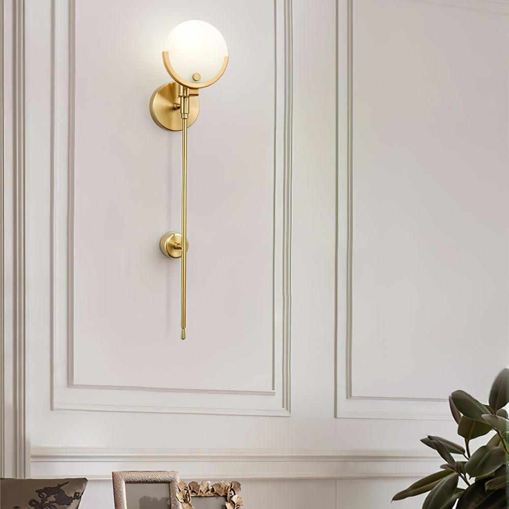 The Clérachic wall light lit on off-white panelling above a console, with a leafy plant to one side.