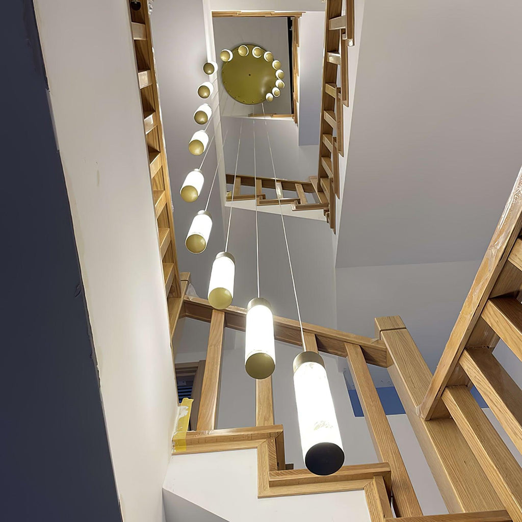 Clérachic Zeal chandelier installed above an oak staircase, the lit drops seen from the floor through the stairwell.