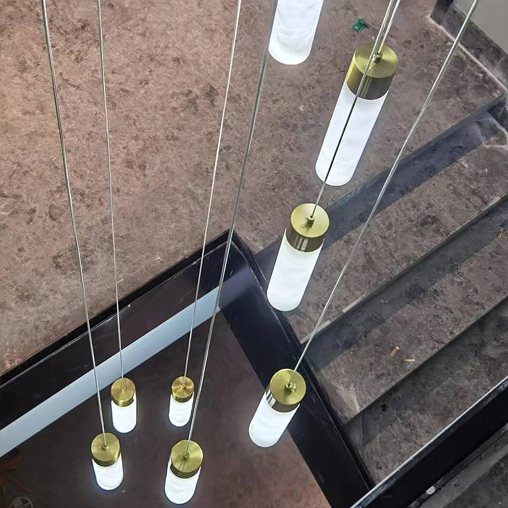 The Clérachic Zeal cascade photographed from above on a marble stair, each alabaster tube glowing along its length.