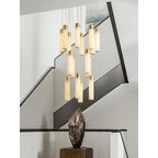 Clérachic Zeal chandelier over a white open staircase with a black handrail, drops clustered at two heights.
