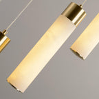 A single Clérachic Zeal drop tilted to camera, showing the open brass end cap and the grain running through the stone.