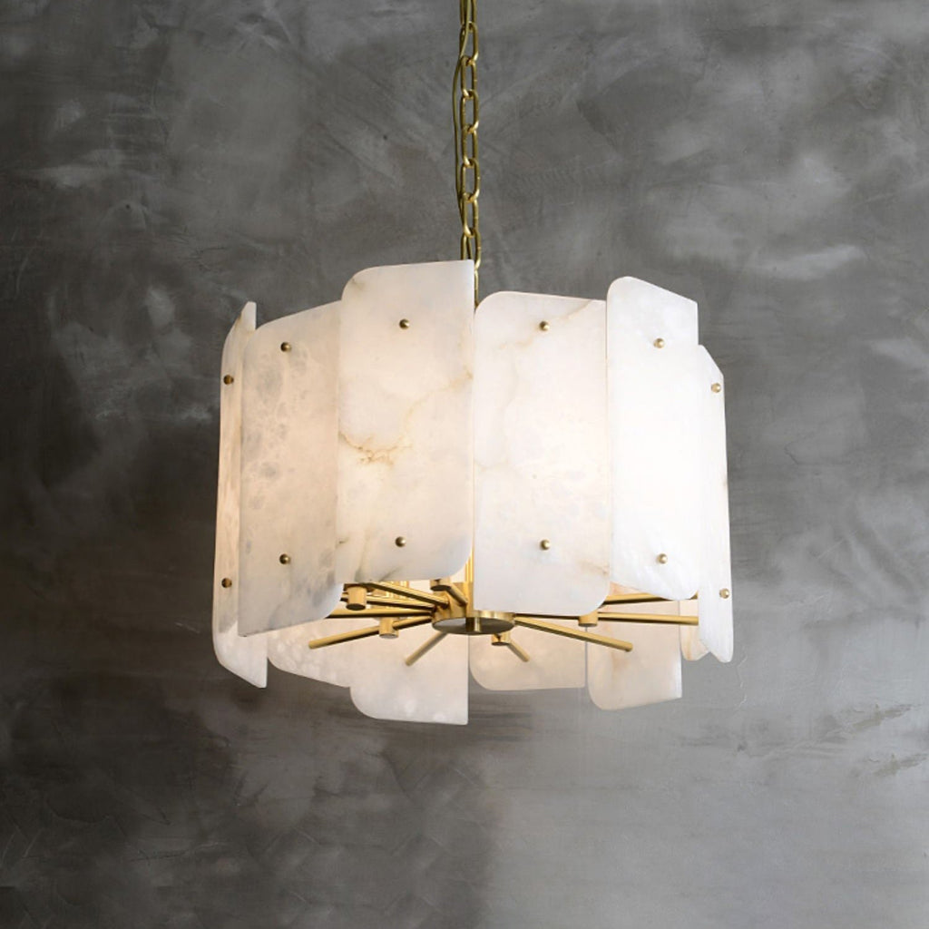 Clérachic Zoe chandelier hung from a brass chain on a grey plaster wall, the cream panels stepping over the radiating brass rods.