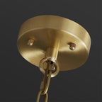 Detail of the round brushed brass ceiling canopy and chain that hang the Clérachic Zoe alabaster chandelier.