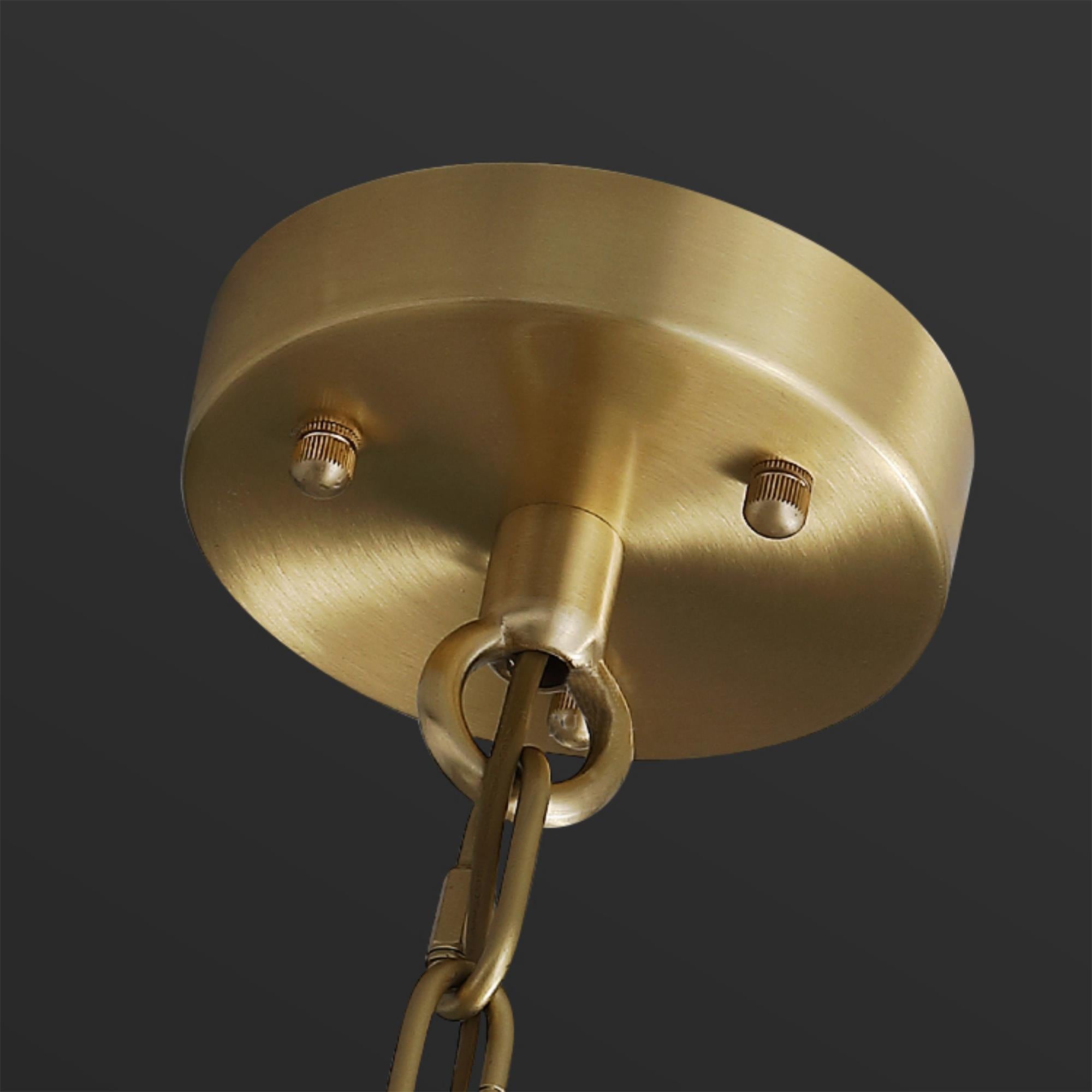 Detail of the round brushed brass ceiling canopy and chain that hang the Clérachic Zoe alabaster chandelier.