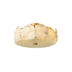 Clérachic disc ceiling light photographed unlit on white, showing its low brass-and-alabaster drum profile.
