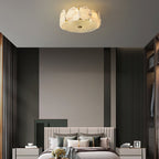 The Clérachic ceiling light fitted in a dark-panelled bedroom, sitting flat against the ceiling above the bed.