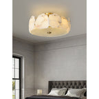 Clérachic flush mount in a bedroom with a tufted headboard and a tall black-framed window alongside.