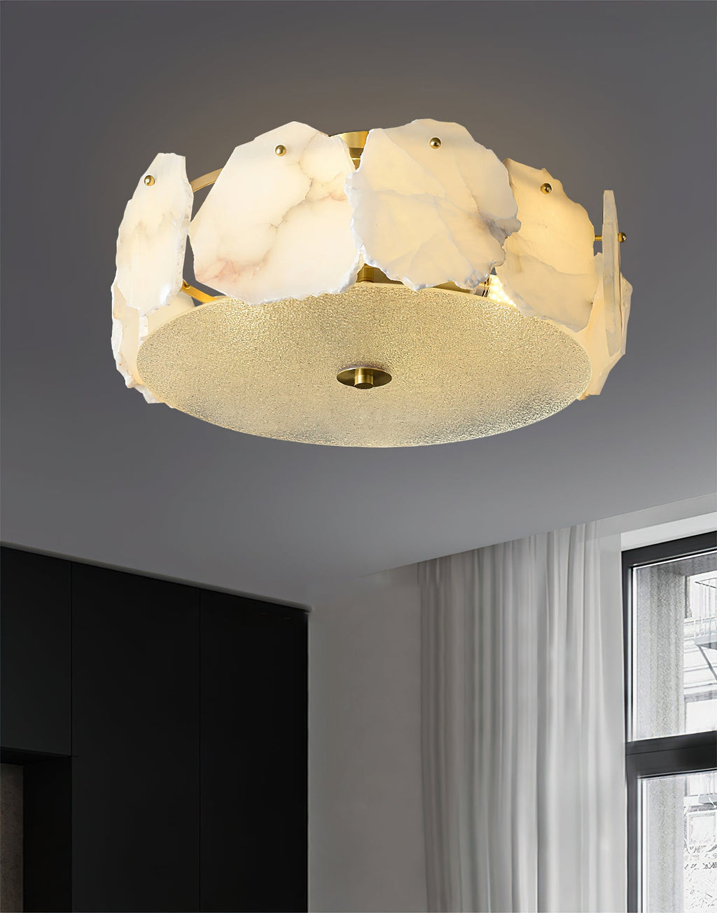 The Clérachic ceiling light beside black wardrobe doors, daylight from the window catching its brass rim.