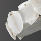 Clérachic detail of the alabaster slabs edge-on, their chipped natural edges meeting the granular glass rim.