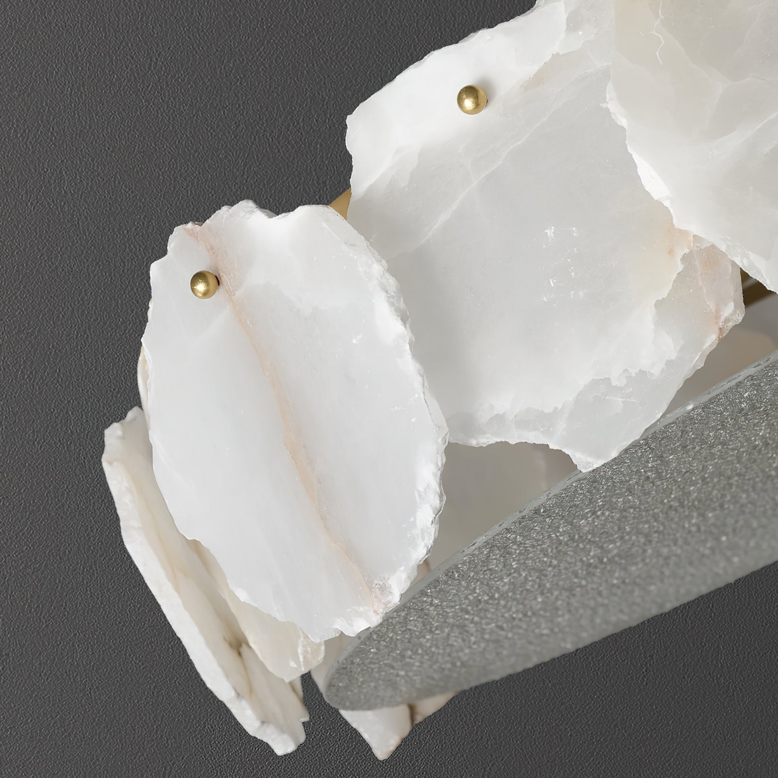 Clérachic detail of the alabaster slabs edge-on, their chipped natural edges meeting the granular glass rim.