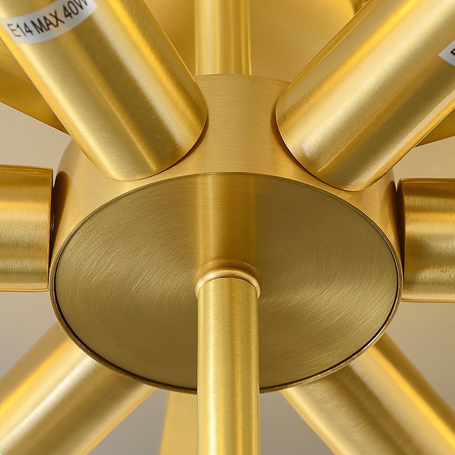 The Clérachic light's brass socket hub seen from below, six brushed brass sockets radiating from the centre.