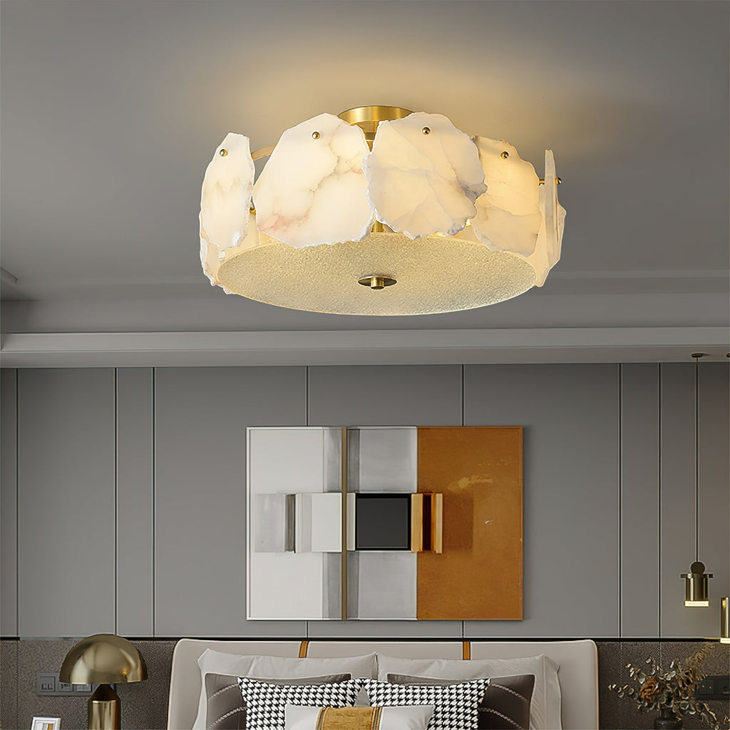 The Clérachic ceiling light in a bedroom with abstract art and brass table lamps, casting a soft warm pool.