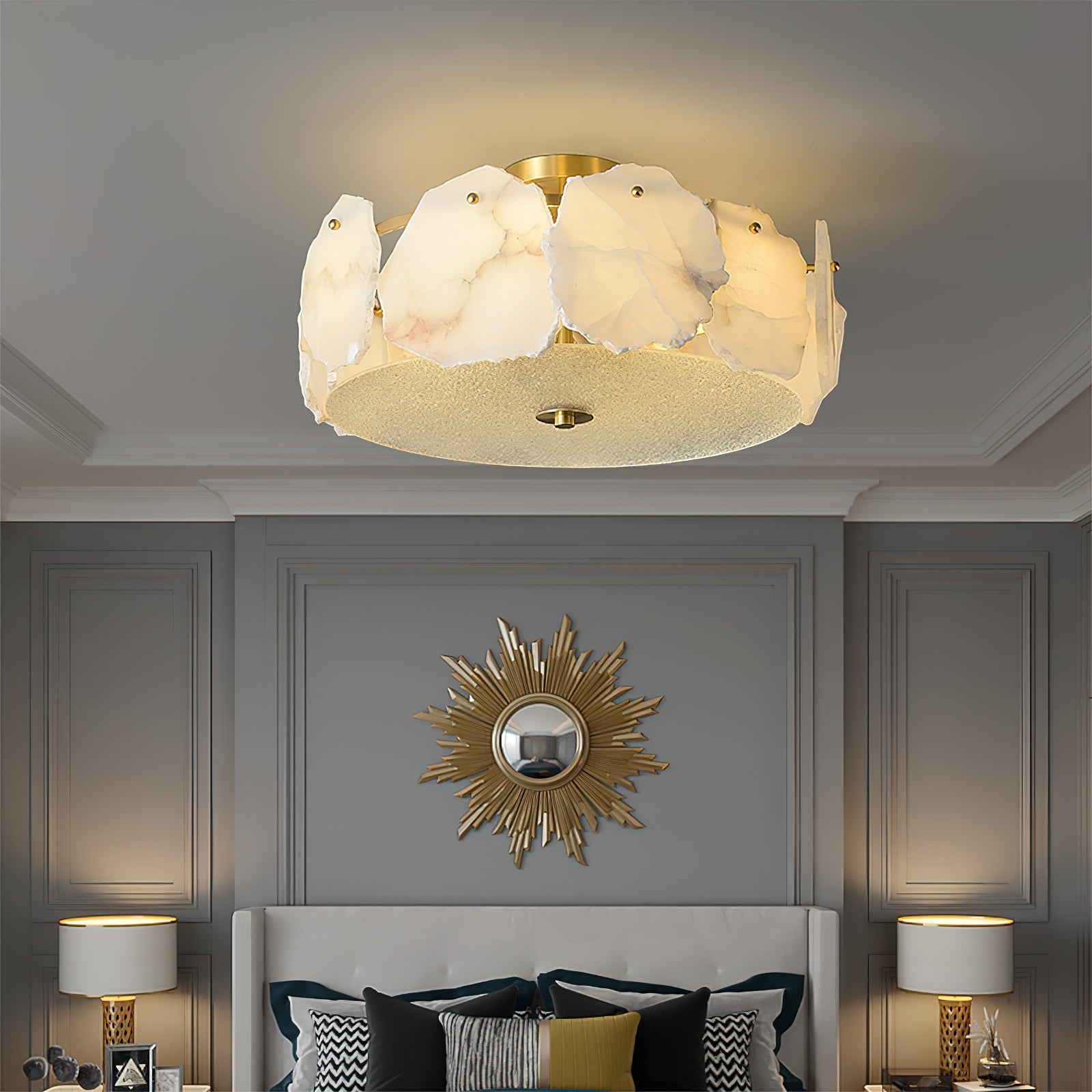 Clérachic flush mount above a bed framed by a gilded sunburst mirror and matching bedside lamps.