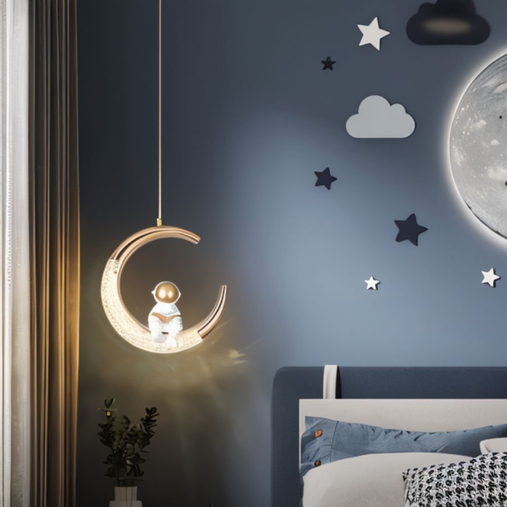 Clérachic moon pendant light glowing beside a bed in a dark blue nursery with star and cloud decor.