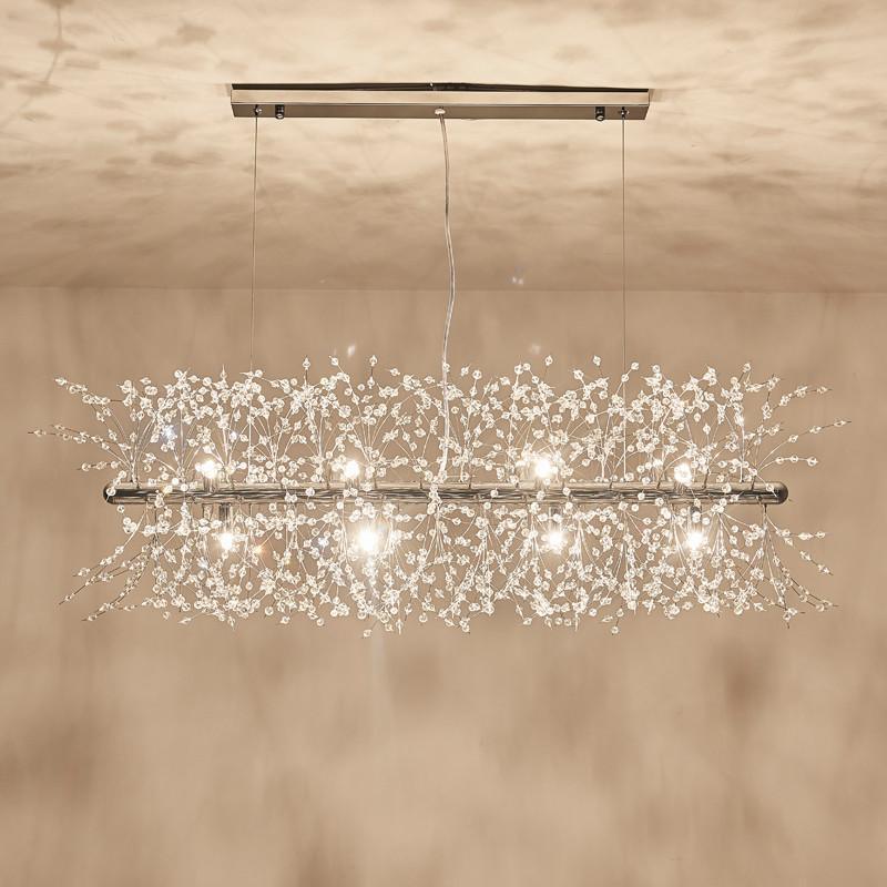 Product shot of a chrome-finish rectangular bar pendant on a warm beige backdrop, a different Clérachic fixture from this chandelier.