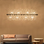 A rectangular gold-bar pendant with crystal-tipped branches hangs above a terracotta sofa and round wood side tables, a different Clérachic fixture from this chandelier.
