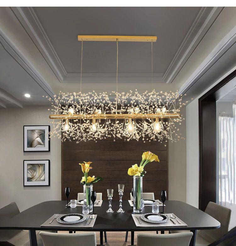 A rectangular gold-bar pendant hangs above a dark dining table set with a floral centrepiece, a different Clérachic fixture from this chandelier.