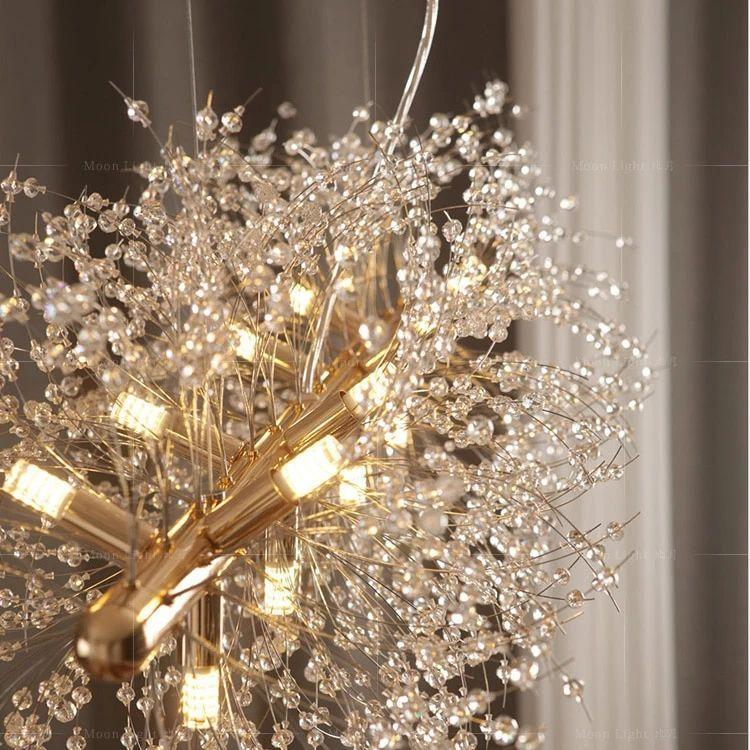 Close view of the gold clasp and lit bulbs at the centre of this Clérachic chandelier's crystal-tipped branches.