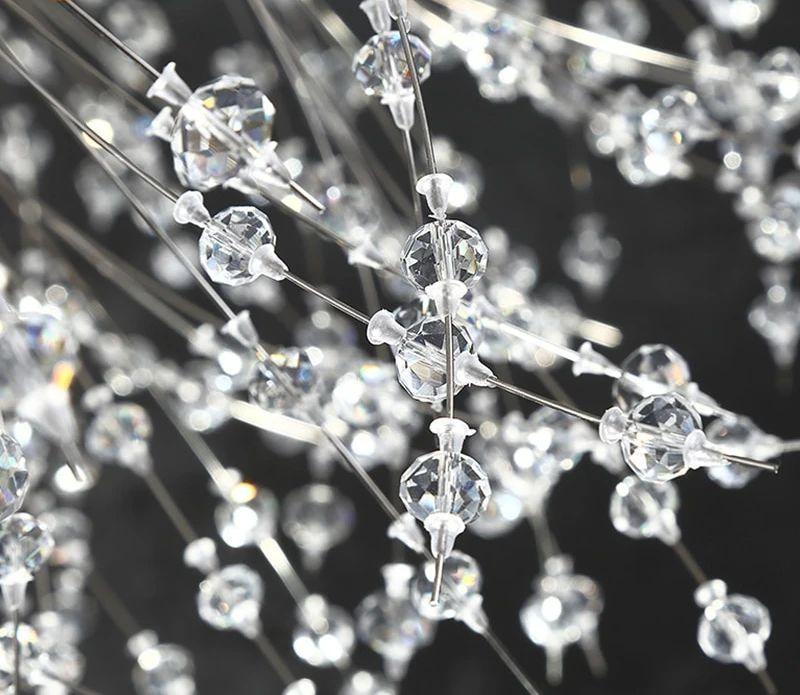 Close-up of faceted crystal beads on wire branches of this Clérachic chandelier against a dark backdrop.