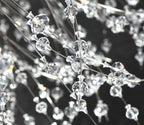 Close-up of faceted crystal beads on wire branches of this Clérachic chandelier against a dark backdrop.