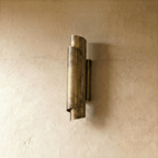 Clérachic wall sconce in vintage brass, its curled cylinder form aimed to throw a soft glow up and down the wall.