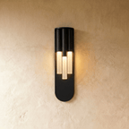 Clérachic wall light in gold, lit warm along its vertical face