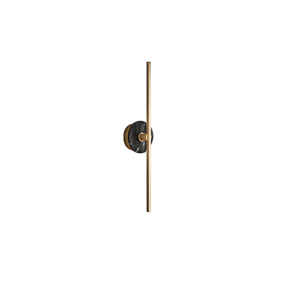 Clérachic wall light on white, a charcoal marbled stone disc set near the top of its slender brass bar.