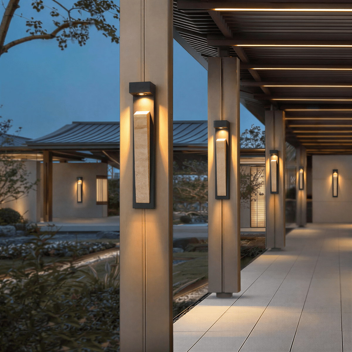 Clérachic wall lamp repeated down a row of columns under a slatted pergola walkway, each one lit at dusk.