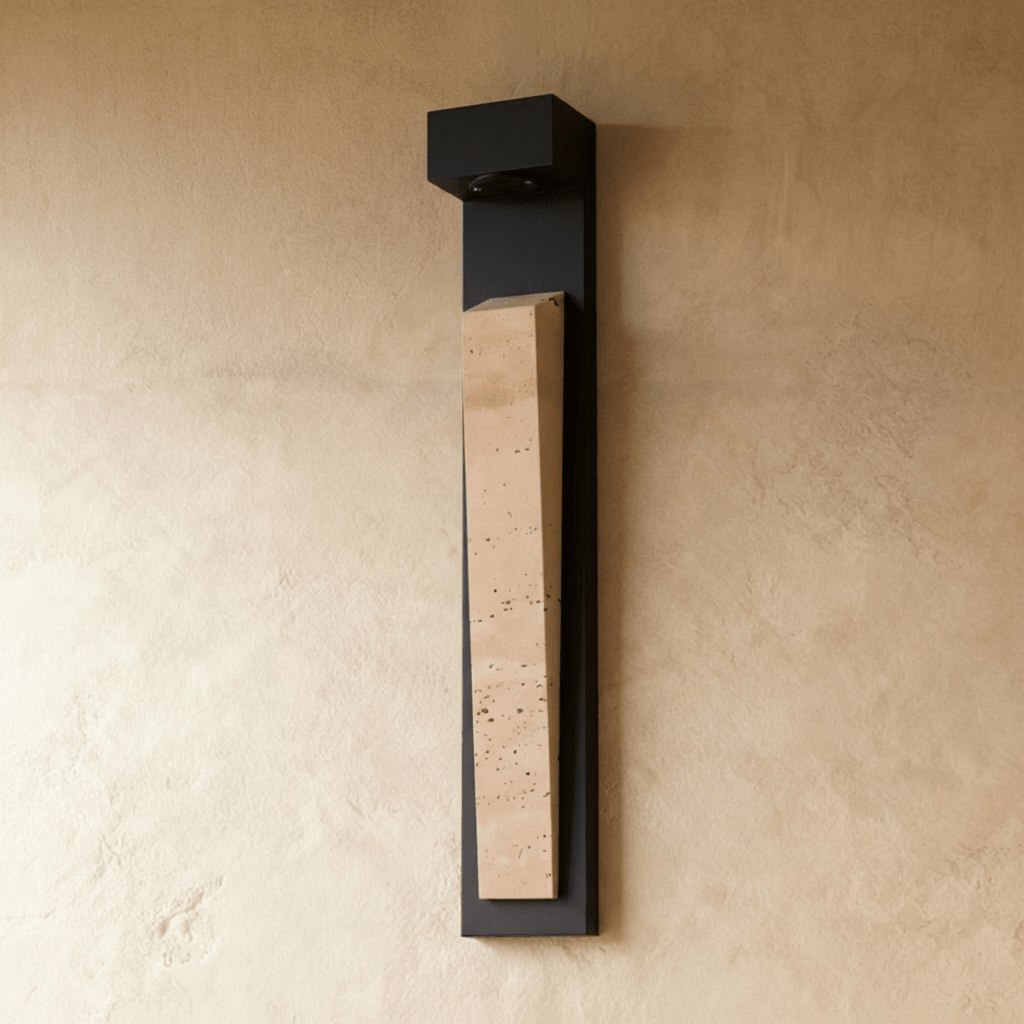 Clérachic wall lamp unlit and seen from the front at a slight angle, its tapered travertine block standing proud of the lower two-thirds of the backplate.