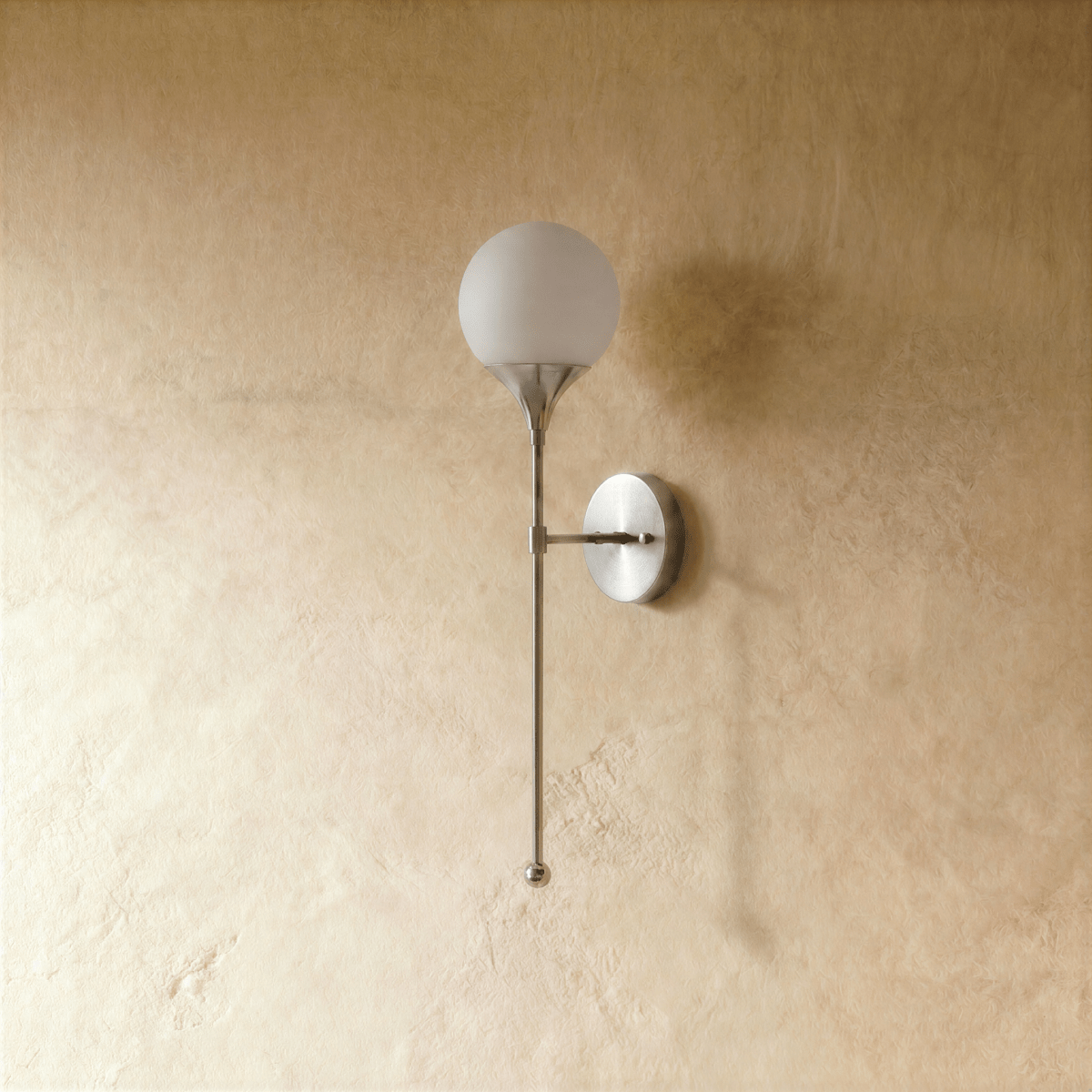 Clérachic wall lamp in chrome, front view of the glass globe shade and its slim mounting arm.